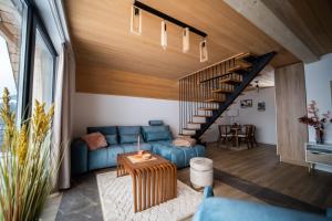 巴伊纳巴什塔Tarvil Apartmani - Zaovine的客厅设有蓝色的沙发和楼梯。