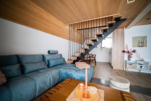 巴伊纳巴什塔Tarvil Apartmani - Zaovine的客厅设有蓝色的沙发和楼梯。