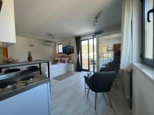 杜布罗夫尼克Apartments and Rooms Maritimo的厨房以及带桌椅的起居室。