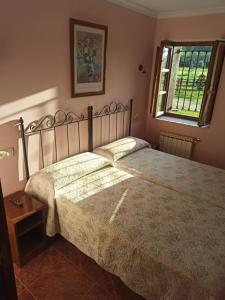 TriongoCASA ALDEA LOS CASTAÑOS的一间卧室设有一张大床和一个窗户。