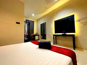 珍南海滩Pemandangan Indah Guest House - Look Out Point Villa-的一间卧室设有一张大床和一台平面电视。