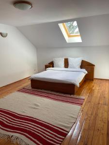 Podu lui NeagCabana Perla Munților - Valea Doftanei的卧室配有一张床,地板上铺有地毯