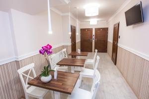 赞布鲁夫Hostel Zambrow的用餐室配有木桌和白色椅子