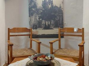 干尼亚Guesthouse Chryssoula的桌子上放着两把椅子和一碗食物