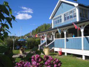 希塞里贝克Wärdshuset Klarälvdalen的前面有鲜花的蓝色房子