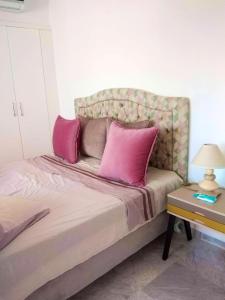 海尔盖莱One bedroom apartement with sea view shared pool and balcony at Hergla的一间卧室配有带粉红色枕头的床。
