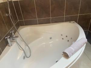 Belcoo草甸景观公寓的浴室设有白色浴缸,配有毛巾