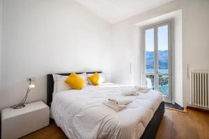 多马索The View Apartment的卧室配有一张带黄色枕头的大型白色床。
