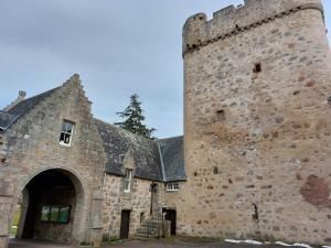 班科里Courtyard Cottage - Drum Castle的一座大型石头建筑,设有大塔