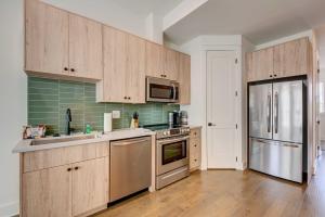 亚特兰大Modern Atlanta Townhome Rental about 2 Mi to Downtown!的厨房配有木制橱柜和不锈钢冰箱。