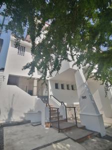 科利马Htl & Suites Neruda, ubicación, limpieza, facturamos的前面有楼梯的白色建筑