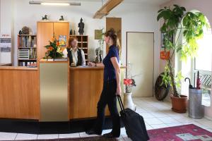 萨尔茨吉特哈尔索夫酒店的带着行李站在柜台上的女人