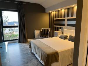 巴雷罗斯A Finca Hotel的卧室配有床、椅子和窗户。