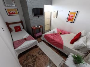 皮雷诺波利斯Pousada Torre dos Mouros的带电视的小型客房中的两张床