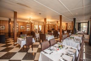 格拉斯科普赫拉斯科普酒店的餐厅内带白色桌椅的用餐室