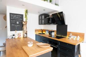 艾格-莫尔特Maison chaleureuse à 5 mins des remparts的厨房配有木制台面和黑色台面