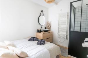 艾格-莫尔特Maison chaleureuse à 5 mins des remparts的卧室配有白色的床和镜子