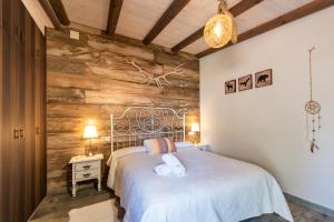 TolosaHostal Avenjúcar的卧室配有白色的床和木墙
