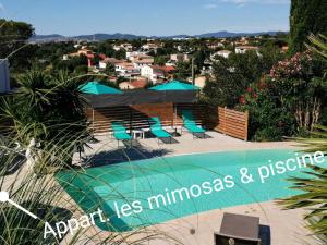 弗雷瑞斯Mimosas - villa的一个带椅子的游泳池,享有城市美景