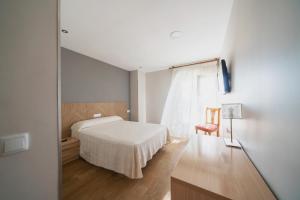杰里亚La Colina的卧室配有白色的床和窗户。