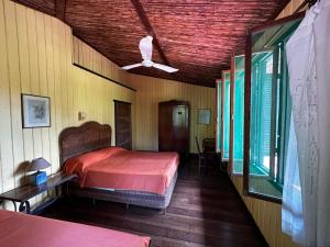 SierpeHotel Veragua River House的一间卧室配有一张床和吊扇