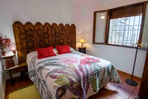 Puebla de Don RodrigoLa Balconera de Ana的一间卧室配有一张带红色枕头的床