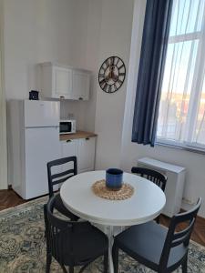 卡雷Weisz Apartment-City Center-Free Private Parking,Wifi,AC的厨房配有白色的桌椅和白色的冰箱。