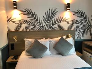 巴黎阿玛德酒店的一间卧室配有一张大床和两个枕头