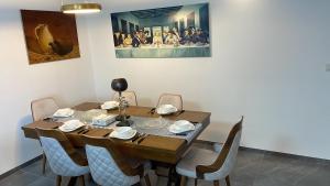 提比里亚חופשה בטבריה בבית ענק ל 8 אנשים גדול וחדש的餐桌、椅子和墙上的绘画
