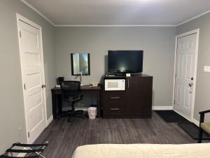 PetawawaTime Travellers Motel的一间卧室配有电视和一张带电脑的书桌