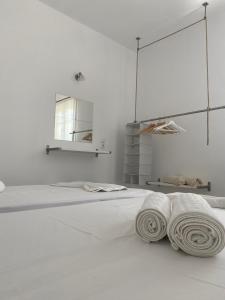 洛加拉斯Klironomos Apartments Logaras的白色客房,配有带毛巾的床