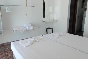 洛加拉斯Klironomos Apartments Logaras的白色客房 - 带两张床和毛巾