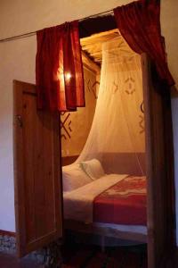 Aït IdaïrRiad Les 5 Lunes的一间卧室配有一张带天蓬的双层床