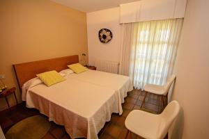 阿尔丹2 bedrooms appartement at Vilanova 100 m away from the beach with sea view enclosed garden and wifi的一间卧室配有一张床和两把白色椅子
