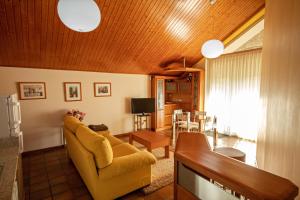 阿尔丹2 bedrooms appartement at Vilanova 100 m away from the beach with sea view enclosed garden and wifi的客厅配有黄色沙发和电视