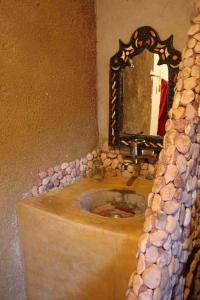 Aït IdaïrRiad Les 5 Lunes的一间带石制水槽和镜子的浴室