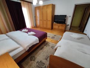 尼亚卢卡Apartman Ruza的酒店客房设有两张床和电视。