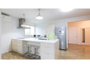 立山町TEA TREES - Vacation STAY 86532v的厨房配有白色橱柜和不锈钢冰箱