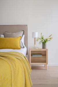 开普敦Neighbourgood Old Cape Quarter的一张黄色毯子和一个植物床头柜的床