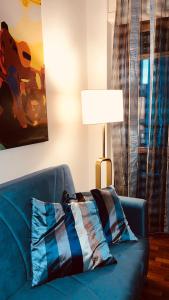 菲乌米奇诺Appartamento tra Aeroporto DaVinci e Fiera di Roma的客厅里设有蓝色的沙发,配有灯