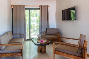萨玛拉Residencias Samara的客厅配有两把椅子、一张桌子和一台电视