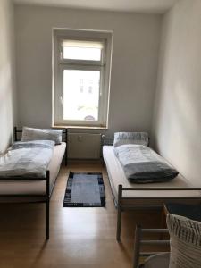 莱比锡Monteurwohnung in Leipzig的带窗户的客房内的两张床