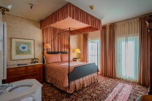 门多西诺门多西诺酒店及花园宾馆的一间卧室配有天蓬床和水槽