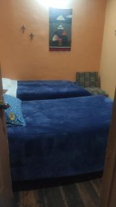 昆卡雀雷恩西亚旅馆的一间卧室配有两张蓝色床单