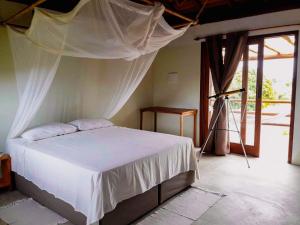 马劳Morada Luz das Estrelas Barra Grande的一间卧室配有一张带蚊帐的床