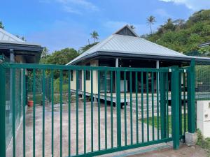 波拉波拉Fare Luna - Comfy New home in Bora Bora的建筑物前的绿色金属栅栏