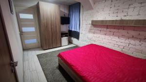 基辅Міні Готель "БУНКЕР" на Солом'янському的一间卧室设有红色的床和砖墙