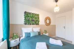 拉尼Sweethost - L'Amazone - T2 Proche Gare & Disneyland的卧室配有蓝色的床和墙上的绘画作品