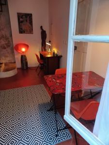 阿尔勒奥昂格斯酒店的客厅配有红色桌子和书桌