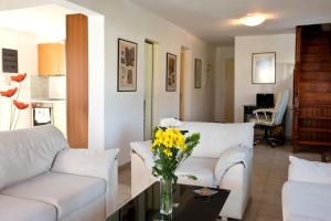 吉奥塔略Villa Nefeli的客厅配有2张白色沙发和1瓶黄色花卉